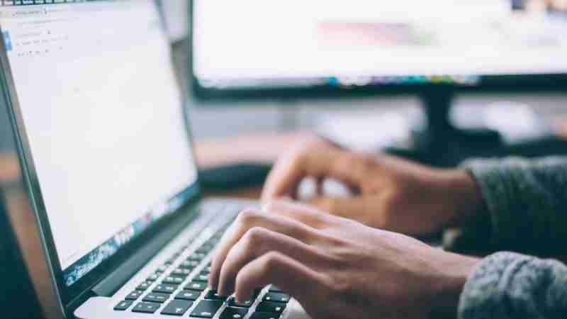 Vingers die typen op een laptoptoetsenbord