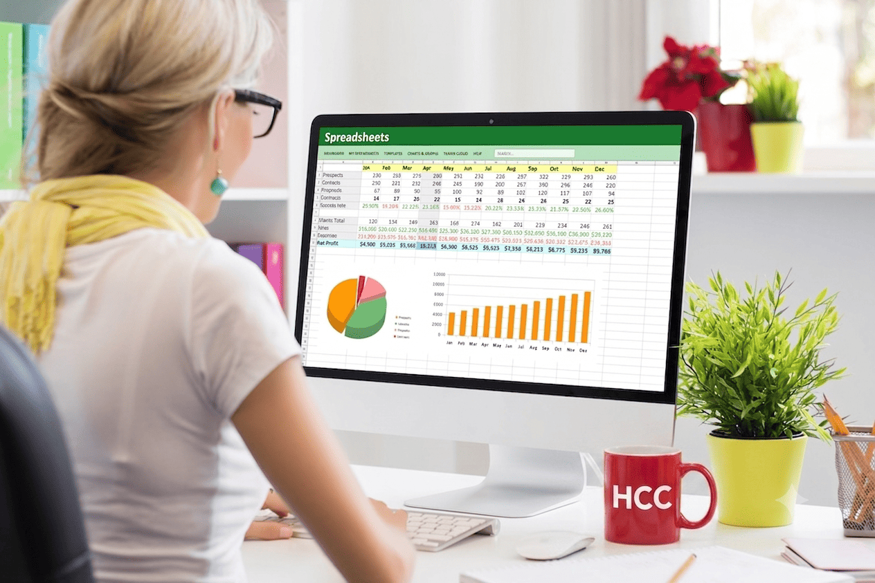 Blonde dame met bril werkt op computer met excel