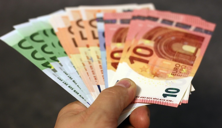 Hand met een waaier aan euro bankbiljetten