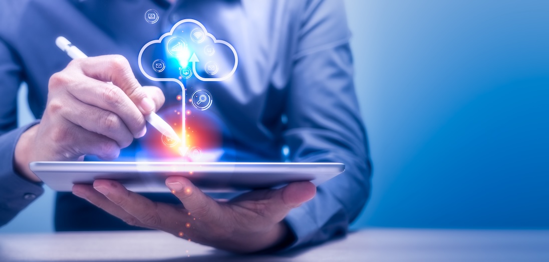 Man typt iets op tablet en er komt een wolkje (cloud) uit die tablet