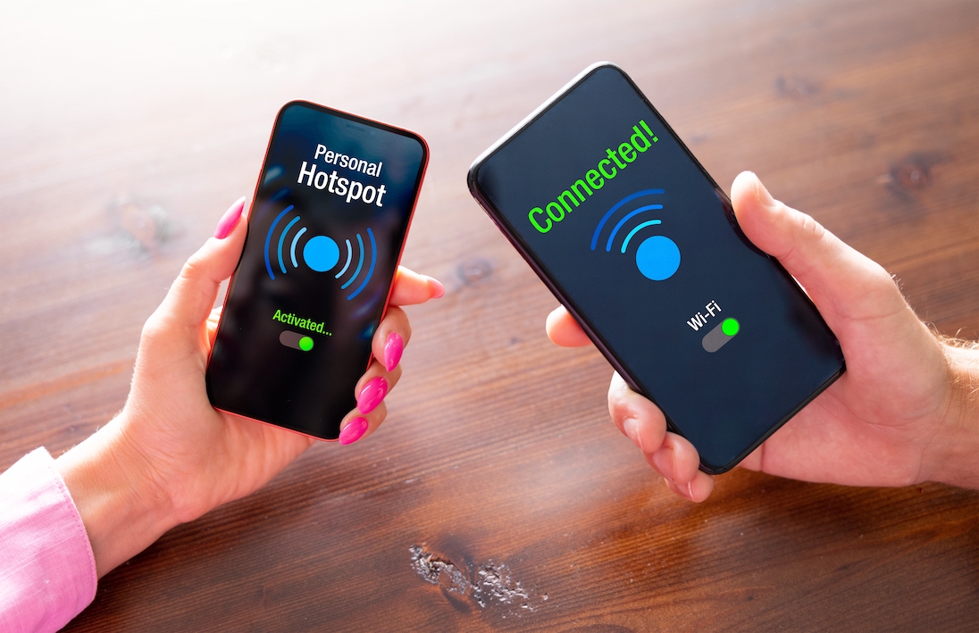 Twee handen die smartphones vasthouden en onderling een hotspot verbinding maken