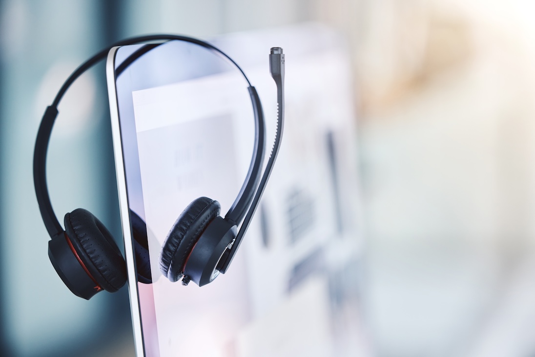 Headset hangende over scherm van laptop