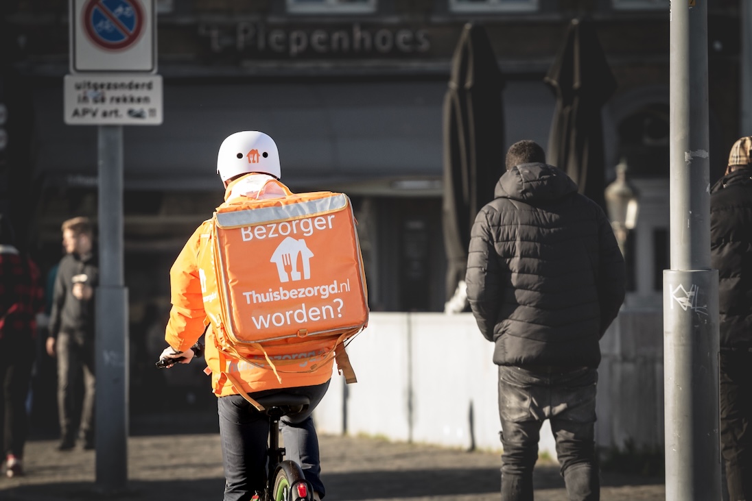 Bezorger van thuisbezorgd.nl op fiets in een stad
