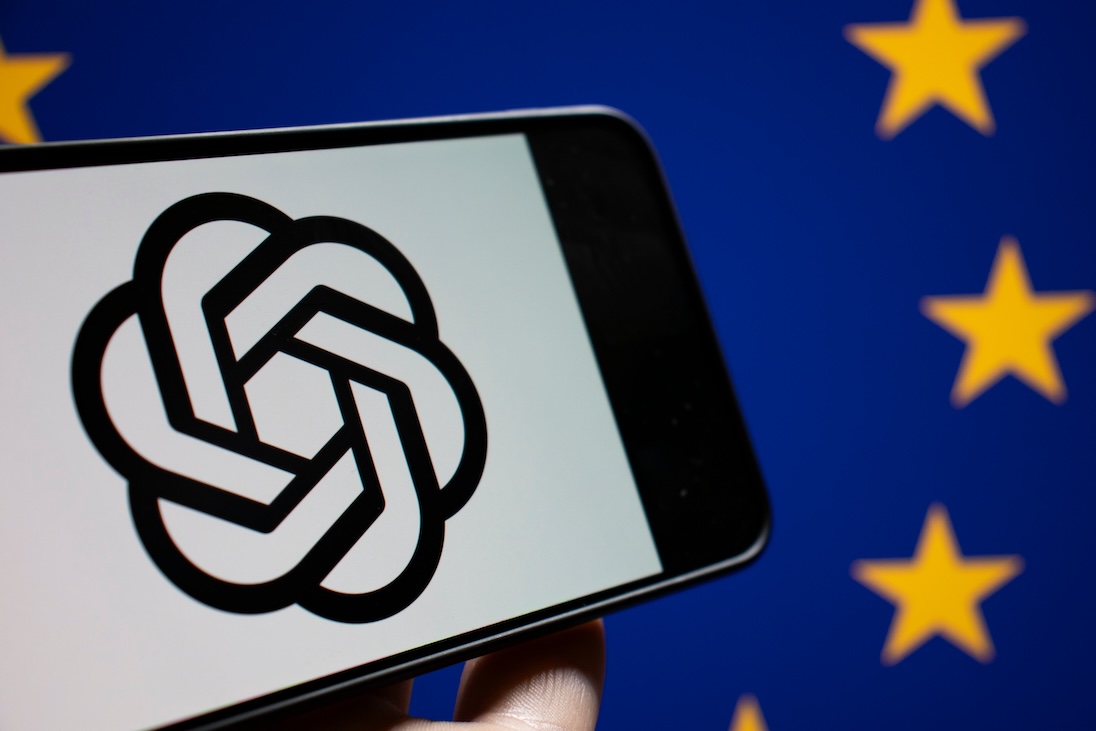 Smartphone met logo van ChatGTP met daarachter de vlag van de EU