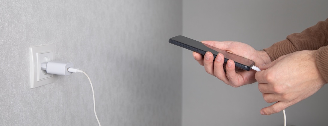 Man sluit kabel aan op smartphone. om op te laden