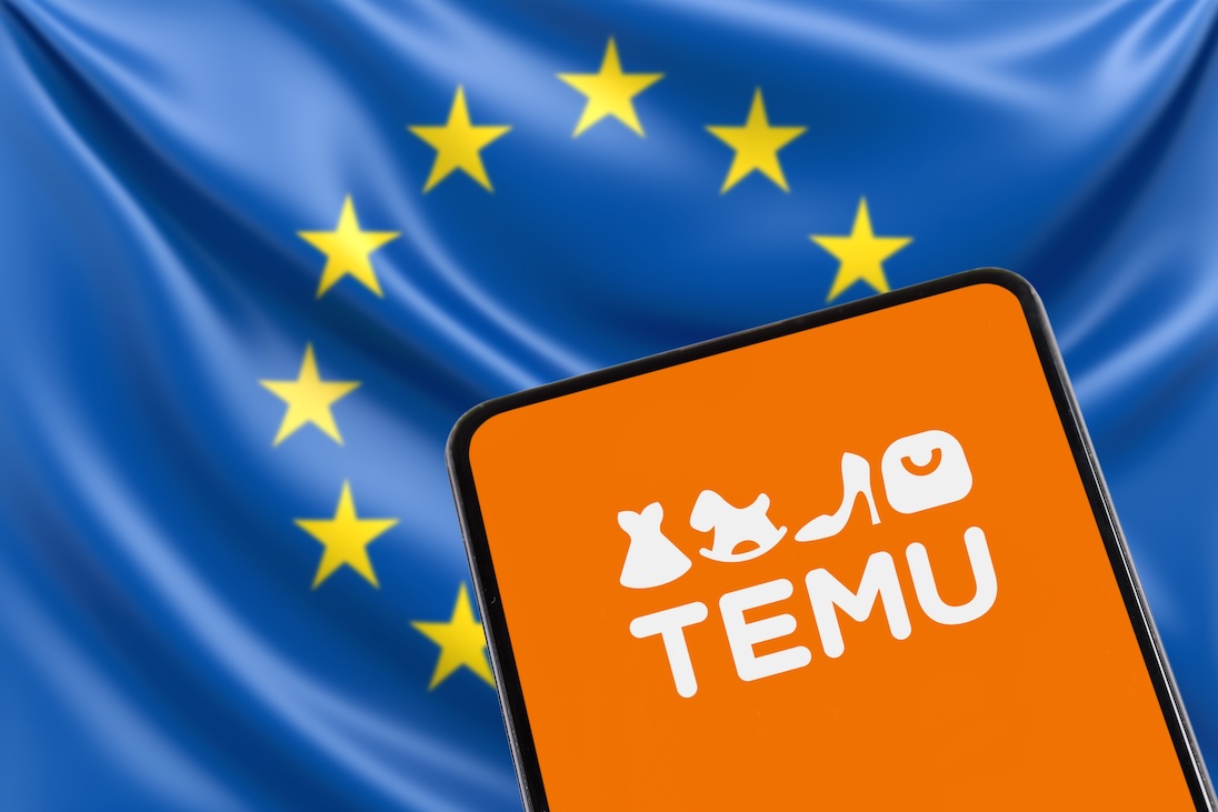 Logo van TEMU op scherm van een smartphone met daarachter de vlag van de EU
