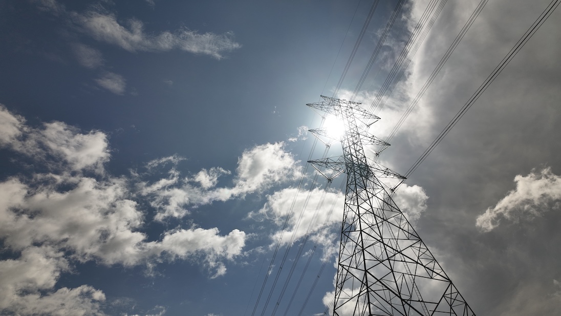electriciteiskabels, met op achtergrond een blauwe hemel met een paar wolken