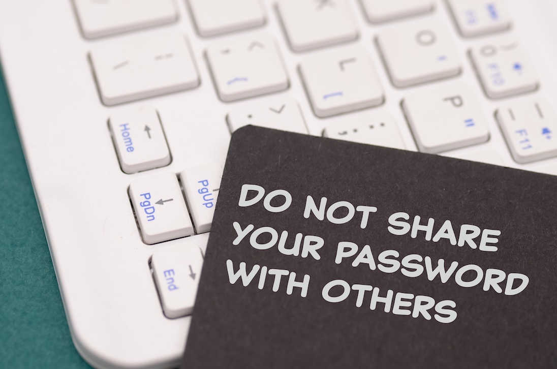 toetsenbord van laptop met daarop briefje met tekst DO NOT SHARE YOUR PASSWORD WITH OTHERS